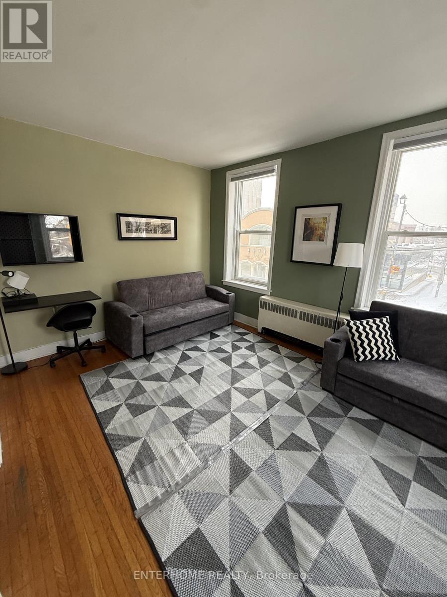 A living room with a grey sofa and a grey rug.