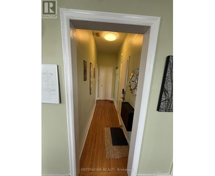 A hallway with a brokerage sign on the door.