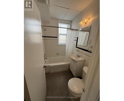 A bathroom with a toilet, sink, and bathtub.