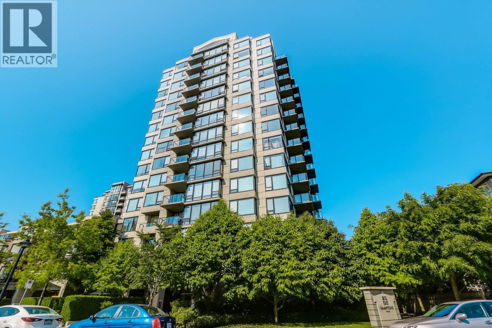 A tall residential building with a clear blue sky in the background.
