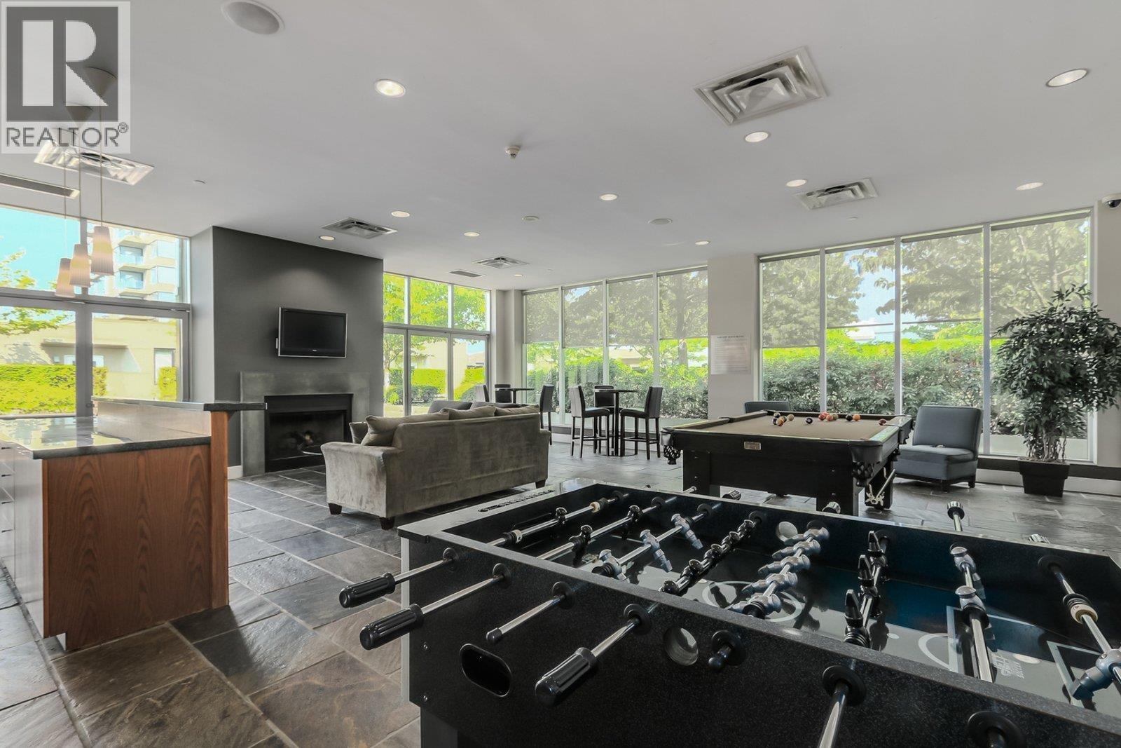 A pool table is in the middle of a room with a fireplace and a TV.