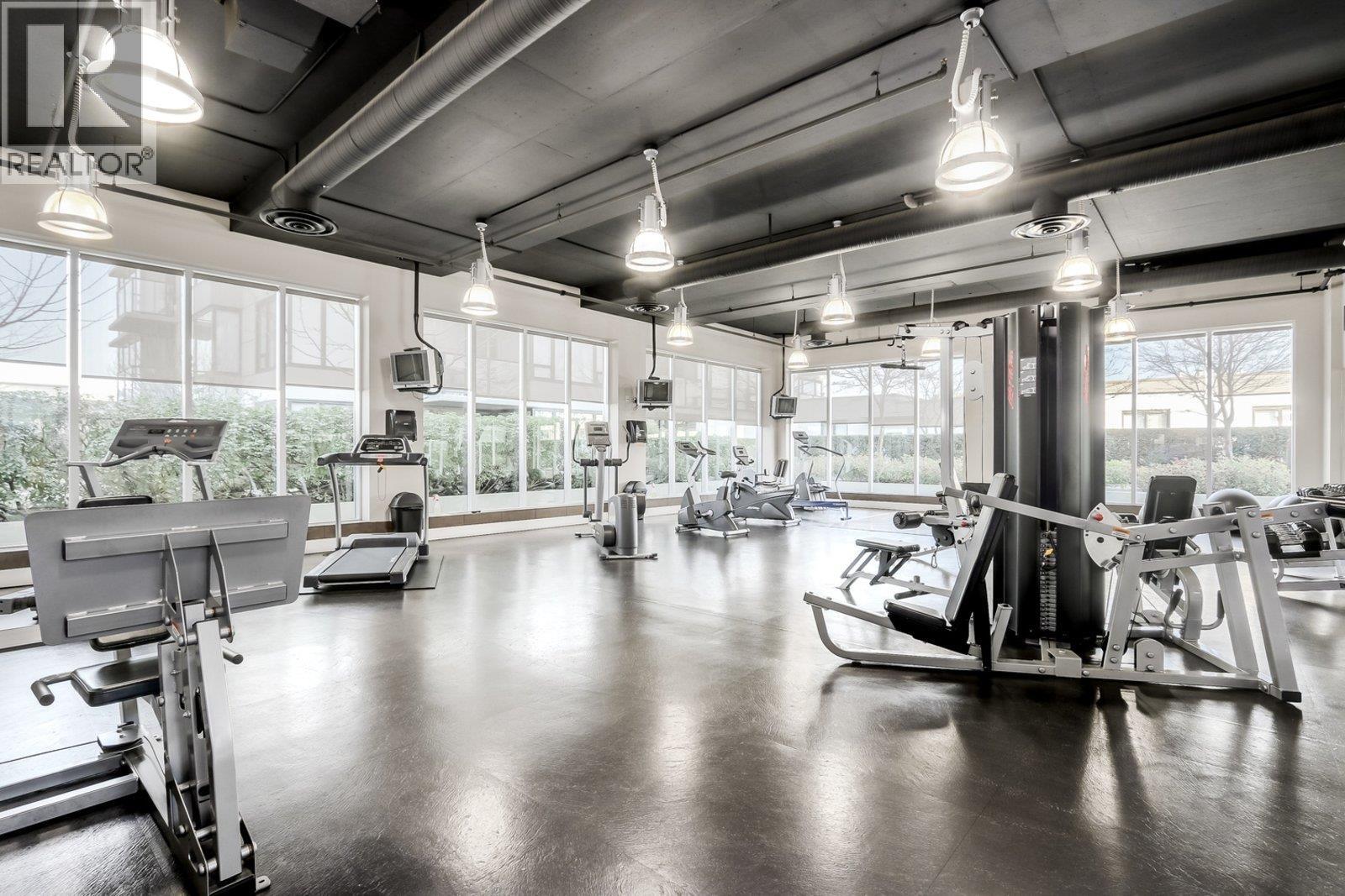 A gym with a variety of equipment including treadmills, weights, and exercise machines.