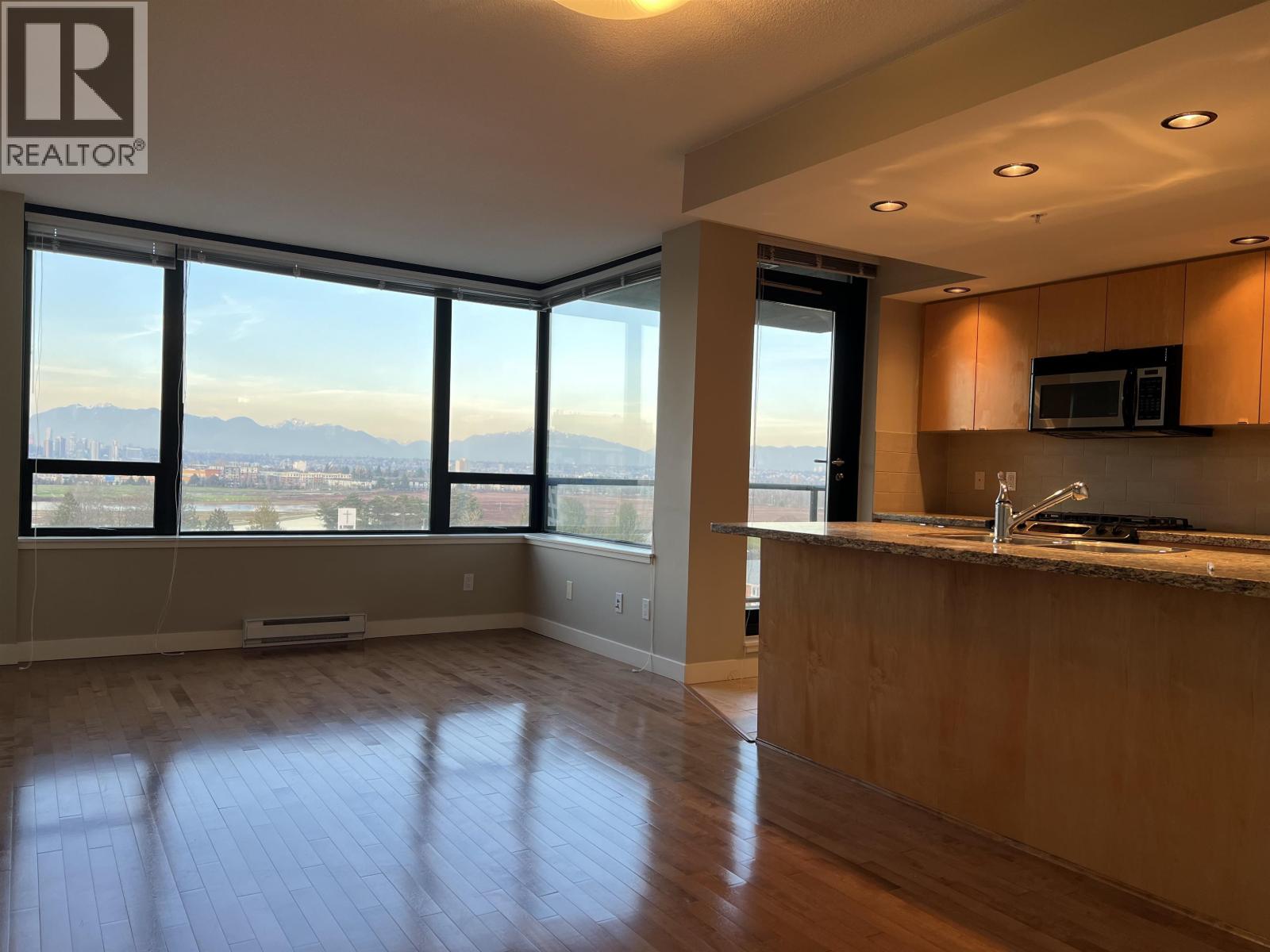 A spacious kitchen and living room with a view of the cityscape.