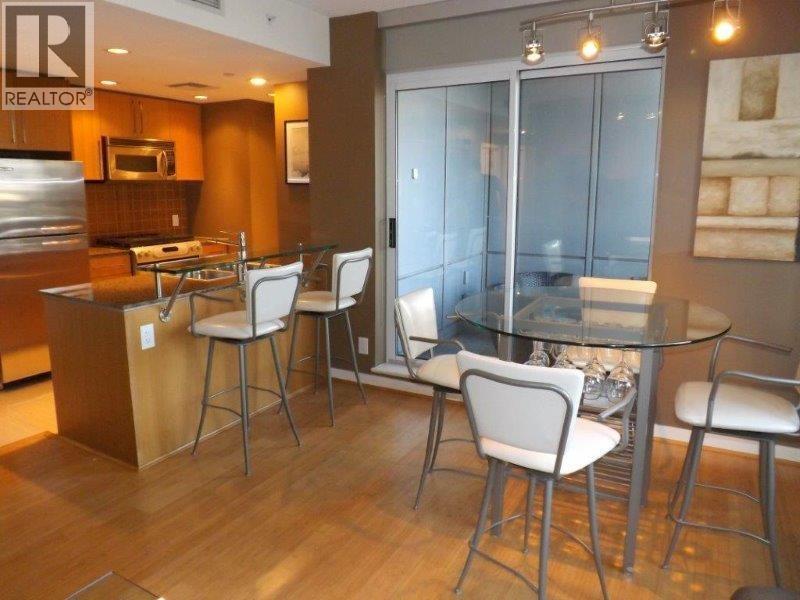 A modern kitchen with a glass table and chairs.