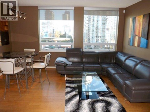 A living room with a leather couch and a glass table.