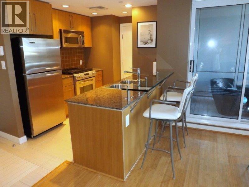A kitchen with a wooden island and a refrigerator.