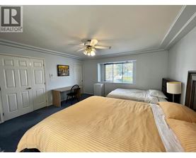 A bedroom with a large bed and a ceiling fan.