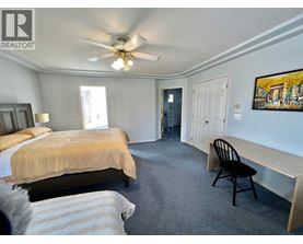 A bedroom with two beds and a ceiling fan.