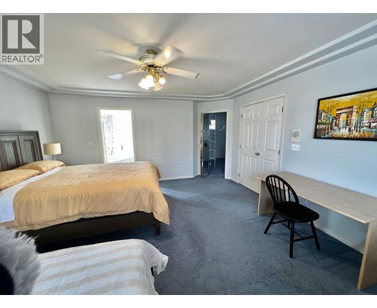 A bedroom with two beds and a ceiling fan.
