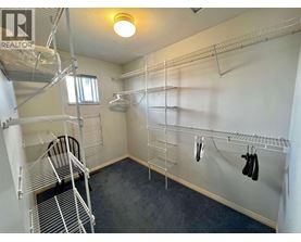 A room with a lot of shelves and a chair.