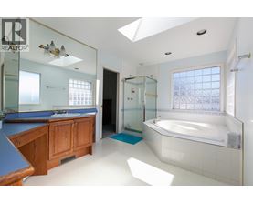 A bathroom with a skylight and a bathtub.