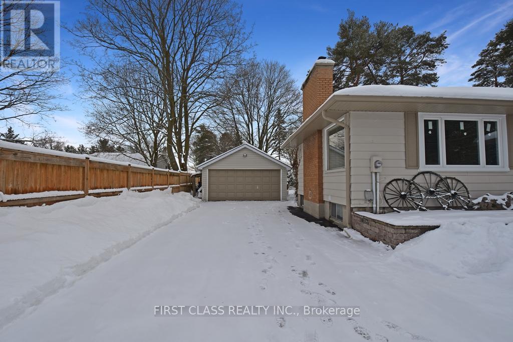 A snow-covered driveway leads to a house with a garage.