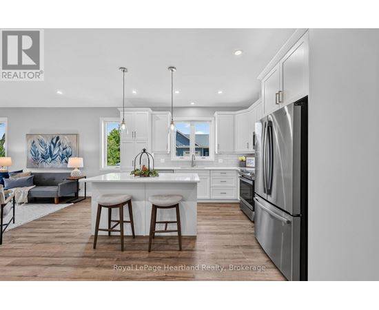 A modern kitchen with white cabinets and stainless steel appliances.
