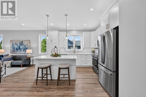 A modern kitchen with white cabinets and stainless steel appliances.