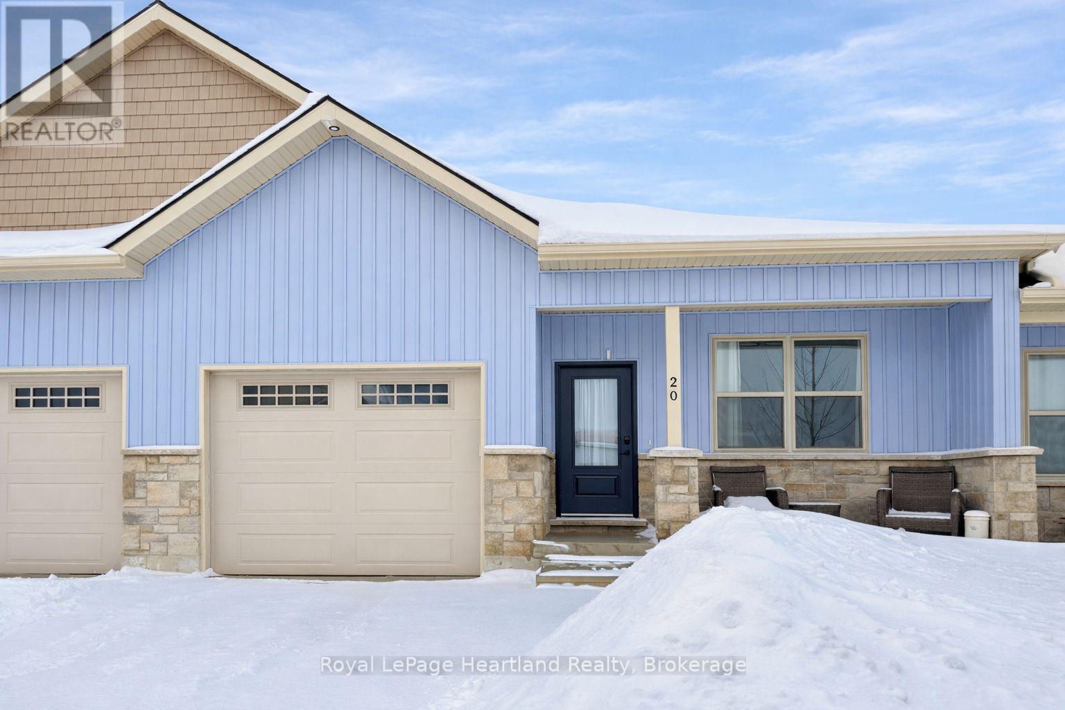 A blue house with a black door and two garages.