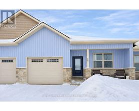 A blue house with a black door and two garages.