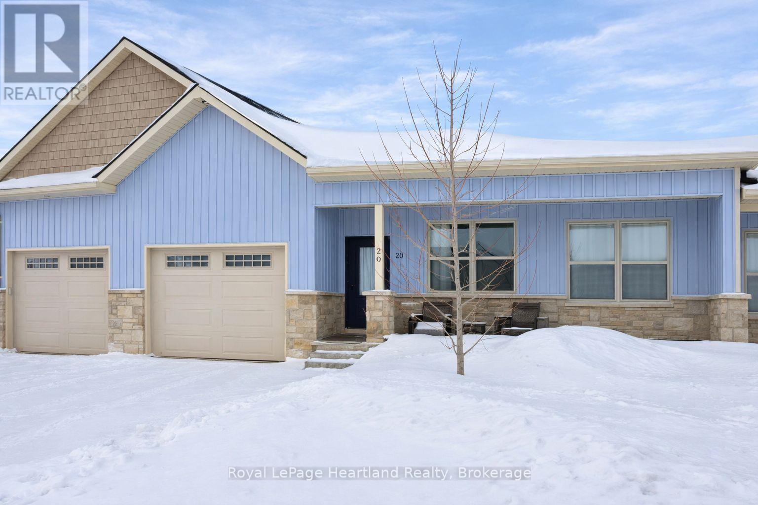 A blue house with a brown roof and two garages.