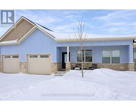 A blue house with a brown roof and two garages.