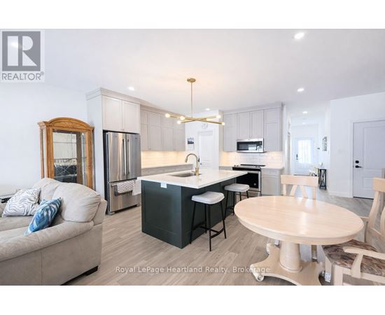 A well-lit kitchen with a dining table and chairs.