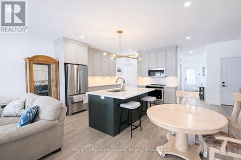 A well-lit kitchen with a dining table and chairs.