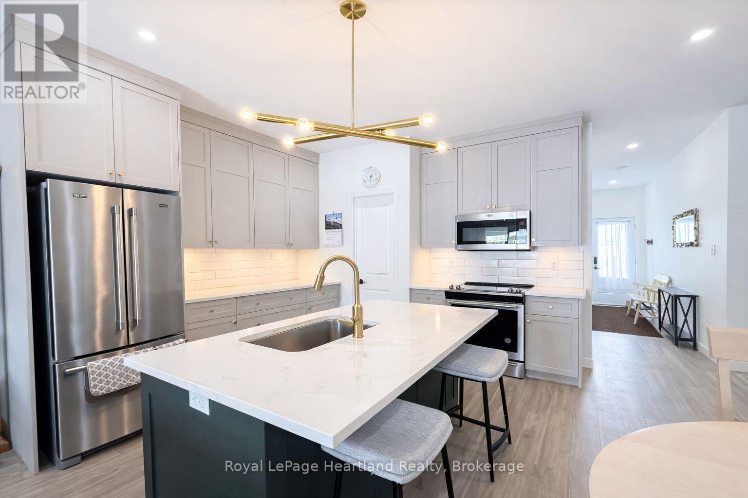 A modern kitchen with a stainless steel refrigerator and a white countertop.