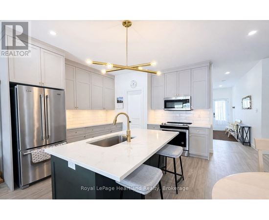A modern kitchen with a stainless steel refrigerator and a white countertop.