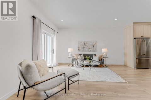 A modern living room with a grey sofa and a wooden floor.