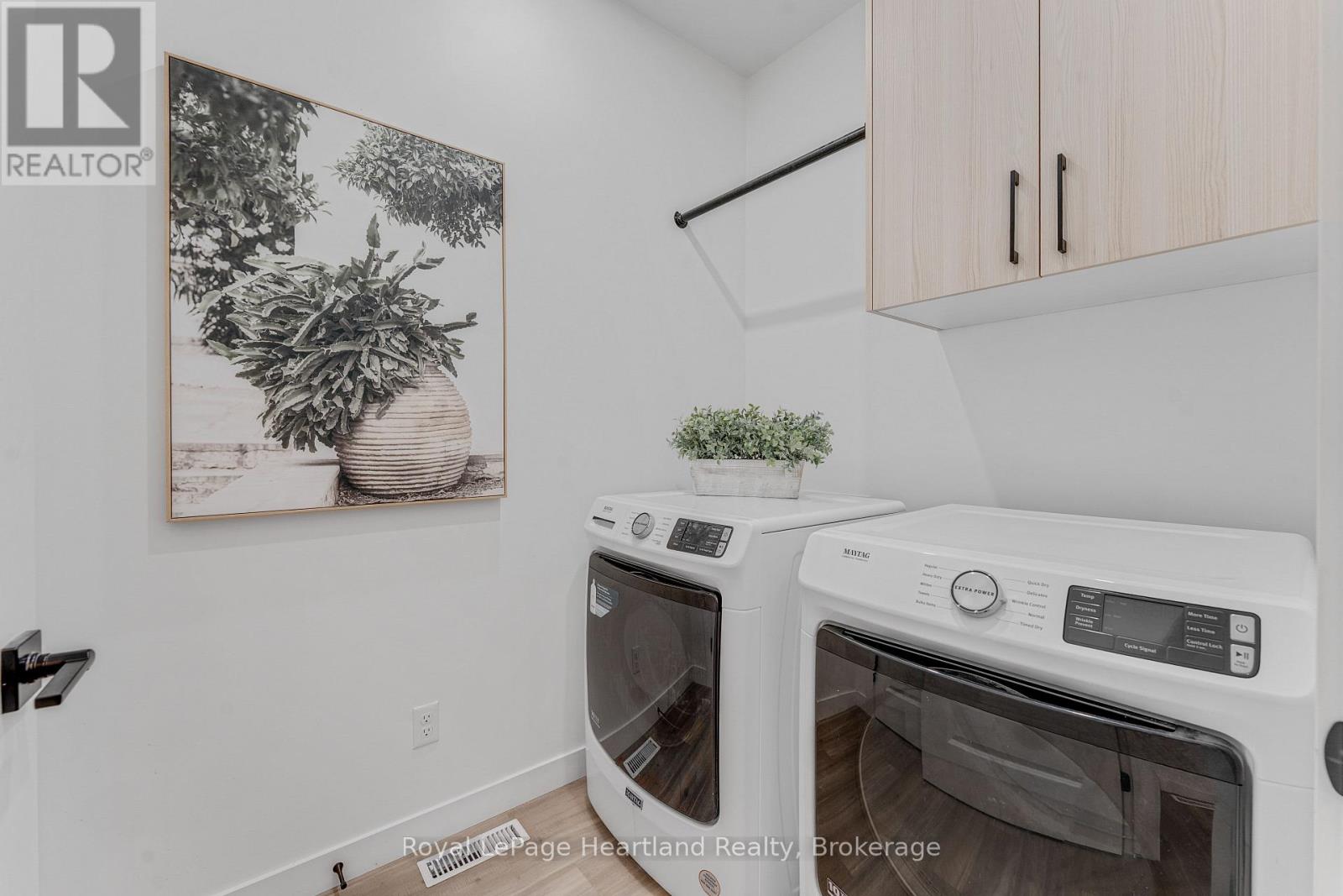 A small kitchen with a white oven and a framed black and white picture on the wall.