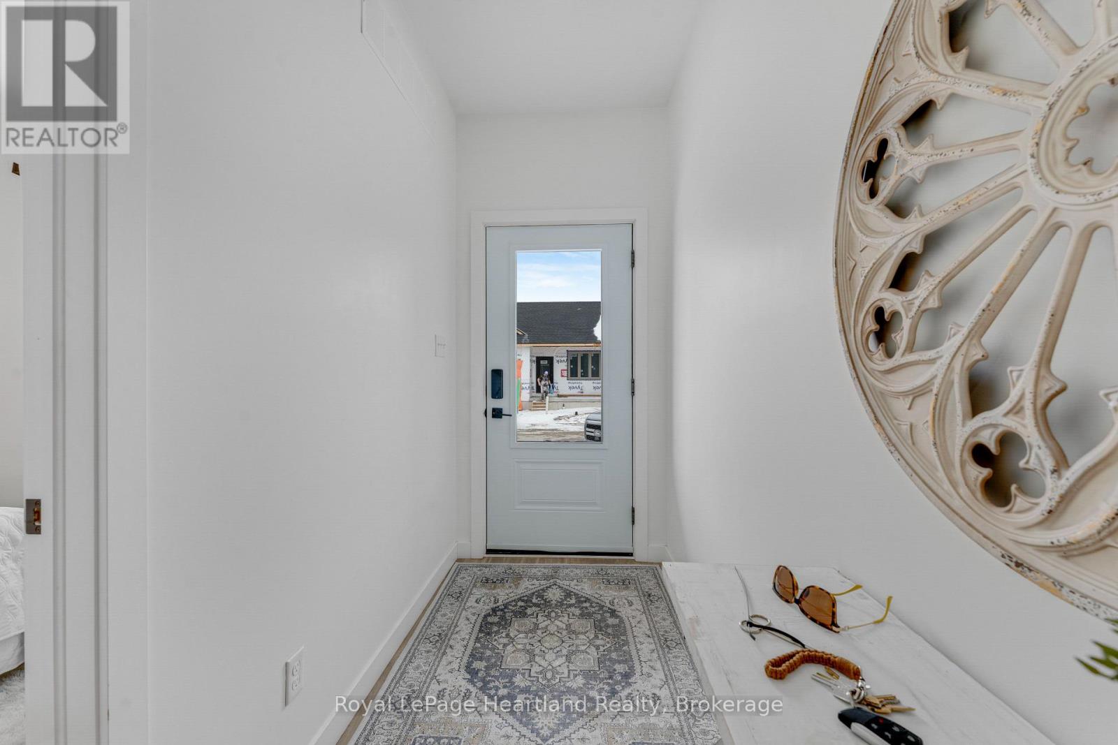 A hallway with a door and a pair of sunglasses on the floor.