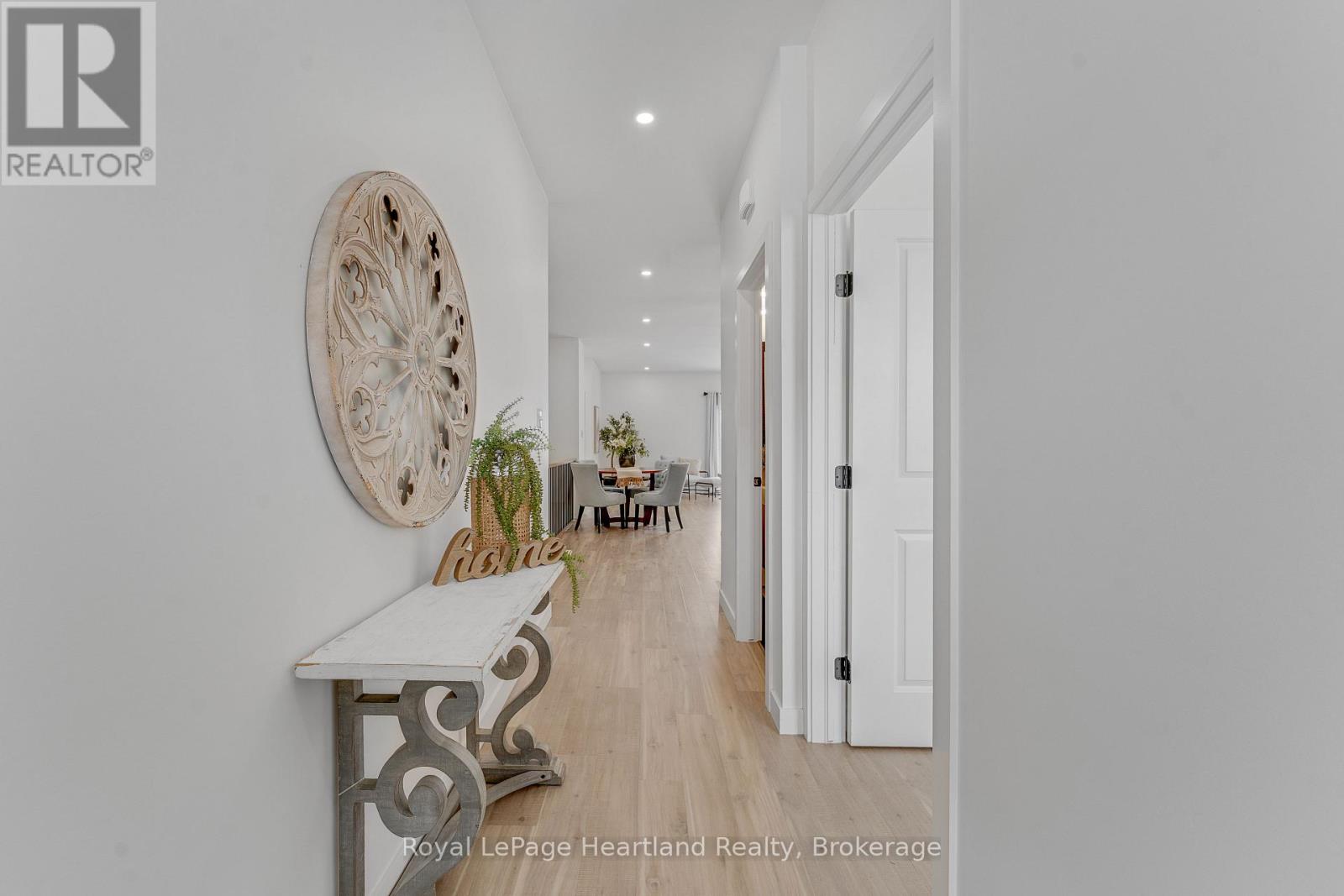 A white hallway with a bench and a circular decoration on the wall.
