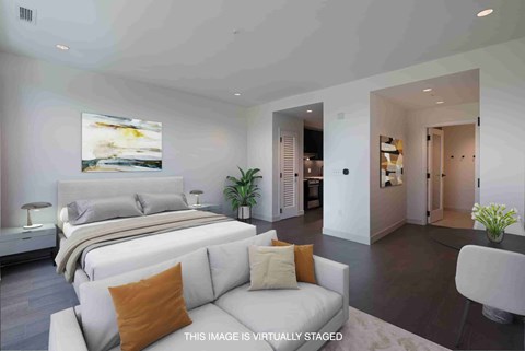 A bedroom with a large bed and a couch with a pillow on it.