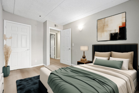 A bedroom with a large bed and a painting on the wall.