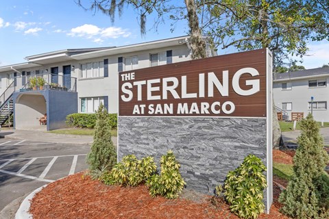 A sign that says "The Sterling at San Marco" in front of a building.