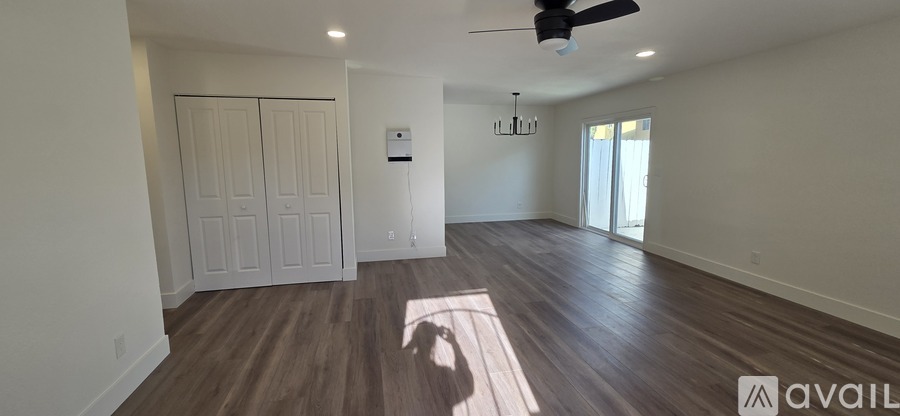 A room with a fan and wooden flooring is available for rent or sale.