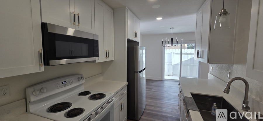 A kitchen with white cabinets and a stove top oven.