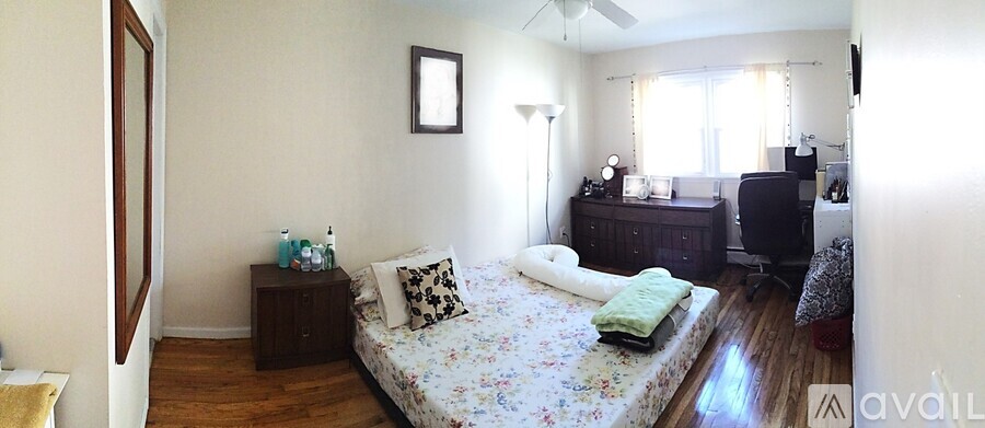 A bedroom with a bed, dresser, and window.
