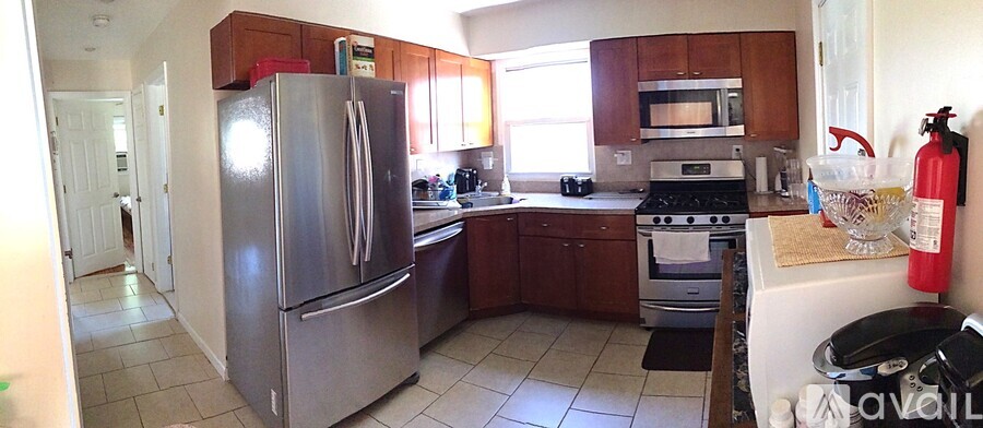 A kitchen with a stainless steel refrigerator and wooden cabinets.