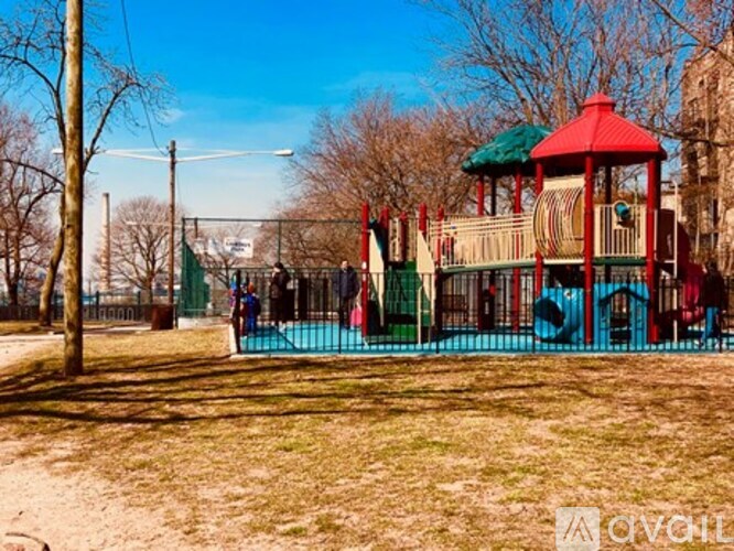 A playground with a red and green structure and a blue slide.