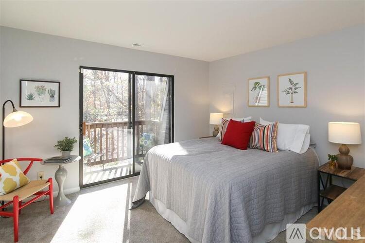 A bedroom with a bed, nightstand, and chair.