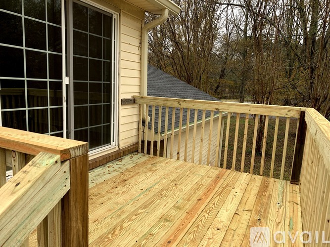A wooden deck with a glass door and a railing.