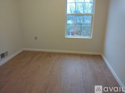 Empty room with wooden floor and a window.
