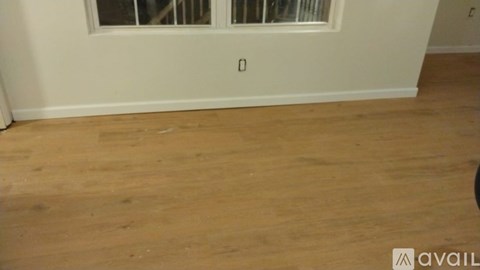 A room with wooden flooring and a window.