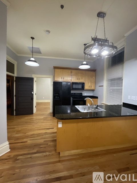 A kitchen with wooden cabinets and a black countertop.