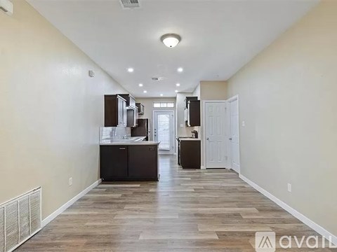 A long, empty hallway with wooden floors and white walls.