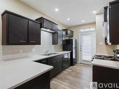 A kitchen with black cabinets and white countertops.
