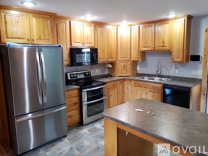 A kitchen with wooden cabinets and stainless steel appliances.