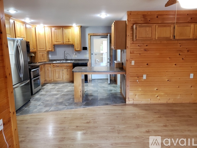 A kitchen with wooden cabinets and a refrigerator.