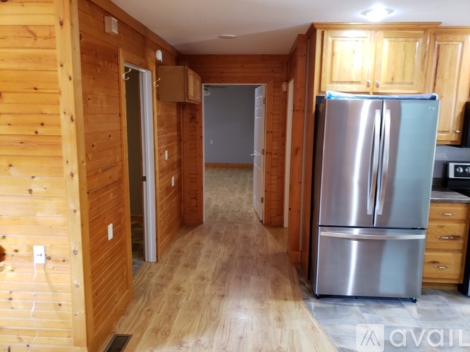 A kitchen with wooden cabinets and a stainless steel refrigerator.