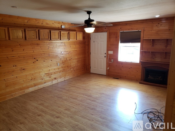 A room with wooden walls and a fireplace.
