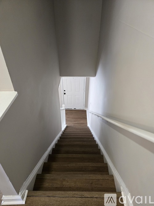 A hallway with a white door at the end.
